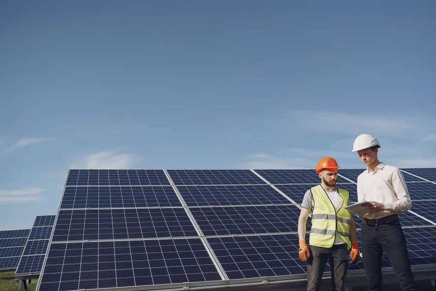 Panel sahasında tabletle iş planını konuşan mühendis ve teknisyen